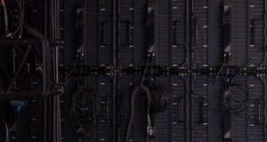 Rear view of a large video display wall with cables and control modules