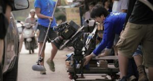 Film crew positioning a camera dolly for a carefully paced shot