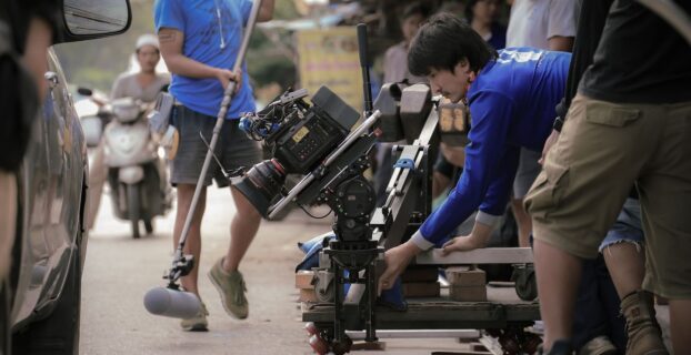 Film crew positioning a camera dolly for a carefully paced shot