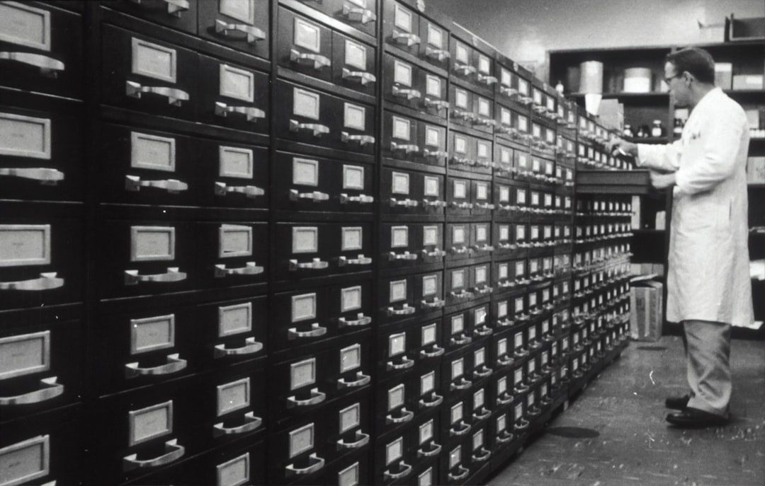Archivist examining rows of labeled drawers in a storage room